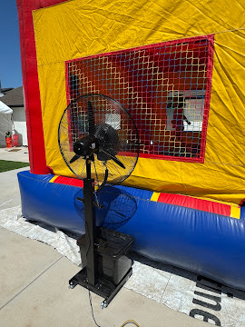 Misting fan cooling a bounce house area